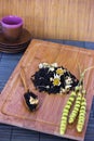 Black friable tea with sage and camomile on wooden spoon on tray