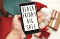 Black Friday big sale text on phone screen. Special discount christmas offer sign. Big Sales. Hand holding phone with advertising Royalty Free Stock Photo