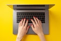 Black friday concept. First person top view photo of female hands typing on laptop keyboard on isolated yellow background Royalty Free Stock Photo