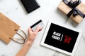 Black friday concept. Hand with debit card make purchase over marble table with tablet, gift box, shopping bag Royalty Free Stock Photo