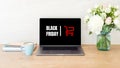 Black friday concept. Laptop computer screen with shopping card and sign Royalty Free Stock Photo