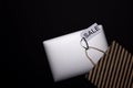 Black Friday concept. Laptop and paper craft bag with black stripes and sale tag on black background. Copy space Royalty Free Stock Photo
