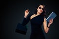 Black Friday and Cyber Monday sale concept for shop. Shopping woman holding bag and pointing on tablet isolated on dark Royalty Free Stock Photo