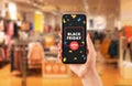 Black friday discount advert on smart phone in woman hand