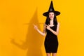 Black friday discount. Photo of cute charming young sorceress lady magician direct finger empty space shiny smile wear Royalty Free Stock Photo