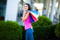 Black friday. Happy woman near shopping mall holding gift bags Royalty Free Stock Photo