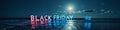 Black friday neon sign on moonlit beach Royalty Free Stock Photo