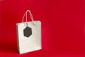 Black friday. Paper bag with sale tag on the red background Royalty Free Stock Photo