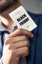 Black Friday`s Sale card holded by an elegant man in suit