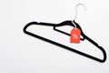 Black Friday sale banner. Coathanger with red tag on white background. Special offer, discount in clothes store concept