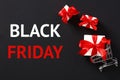 Black Friday sale banner. Shopping cart with gifts inside and message BLACK FRIDAY on black background Royalty Free Stock Photo