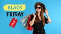 Black Friday Sale. Beautiful young woman with shopping bags on light blue background Royalty Free Stock Photo