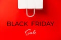 Black Friday sale. Blank white paper bag isolated on red background. Discount, recycling, shopping and ecology concept