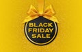 Black Friday sale golden text write on black gift card ball with ribbon bow, isolated on gold background