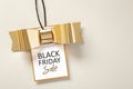 Black friday sale tag with gold bow on beige background Royalty Free Stock Photo