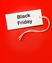 Black friday sale tag red background. White label black friday clothes discount attention Royalty Free Stock Photo