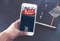 Black Friday sale tag with shopping cart on mobile screen,Hand h