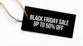 BLACK FRIDAY SALE UP TO 50 percents text on a black tag on a white paper background Royalty Free Stock Photo