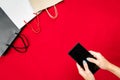 Black friday sale, woman hand online shopping on smartphone with shopping bag on red background Royalty Free Stock Photo