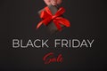 Black Friday Sale. Woman's hand holding black gift box with red bow over black background. Black friday sale Royalty Free Stock Photo
