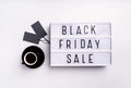 Black Friday Sale words on lightbox with cup of coffee and black price tags top view flat lay on white background Royalty Free Stock Photo