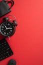 Black friday sales concept. Top view vertical photo of black alarm clock paper bag computer mouse and keyboard on isolated red