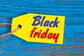 Black Friday sales tag on blue wooden background. Sale, discount, advertising, marketing price tags for clothes