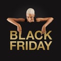 Black Friday shopping. Smiling black woman pointing at a Black Friday golden text on advertising banner commercial sign. Store and Royalty Free Stock Photo