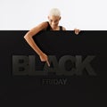 Black Friday shopping. Smiling black woman pointing at a Black Friday text on advertising banner commercial sign. Store and mall