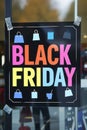 A black friday sign hanging on a store window with shopping bags, AI Royalty Free Stock Photo