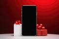 black friday of a smartphone with black ribbon and christmas gifts on a red background . Royalty Free Stock Photo