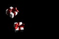 Black friday star. White gift box with red ribbon isolated on black background in Black Friday concept. Winter flying composition Royalty Free Stock Photo