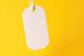 Black Friday. White price tag sticker on a string on a yellow background. AI generated. Royalty Free Stock Photo