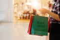 Black Friday, Woman holding shopping bags walking in mall Royalty Free Stock Photo