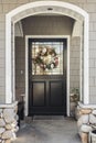 Black front door of a home seen through an arch Royalty Free Stock Photo