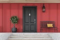 Black front door of red house with tree and bench