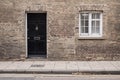 Black front door on a restored brick wall of a Victorian house residential building