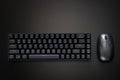 Black gaming compact ergonomic computer keyboard and computer mouse on a dark background. Wireless technology and gadgets. Copy Royalty Free Stock Photo