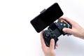 Black gaming joystick with smartphone installed into holder in gamer hands, with blank black screen, Game controller in hand , Royalty Free Stock Photo