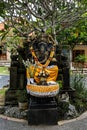 Black Ganesha statue with a wreath of flowers
