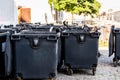 Black garbage bins in the city. Separate waste, preserve the environment concept. Segregate waste, sorting garbage in the town