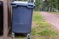 A black garbage trash bin in a forest area. Waste management in mature Waste sorting management in an camping environment. Royalty Free Stock Photo