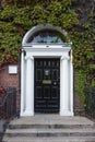 Black Georgian door surrounded by Ivy with doorknob Royalty Free Stock Photo