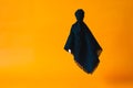 Black ghost sheet flying on orange background.