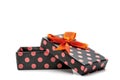 Black gift box with pink dots and orange ribbon Royalty Free Stock Photo