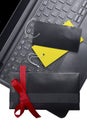 Black gift box with red ribbon and colorful label tag on the laptop