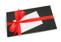 Black gift box with red satin ribbon bow and a blank card Royalty Free Stock Photo