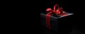 Black gift box with red satin ribbon bow isolated on black Royalty Free Stock Photo