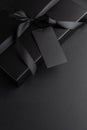 Black Gift Box with Satin Ribbon and Blank Tag on Dark Background Royalty Free Stock Photo