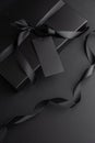 Black Gift Box with Satin Ribbon and Blank Tag on Dark Background Royalty Free Stock Photo